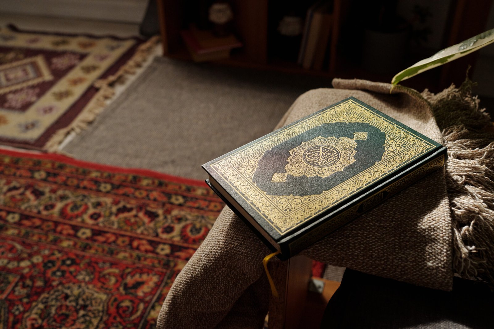 No people high angle of holy Quran book in green hard cover decorated with gold ornaments lying in living room